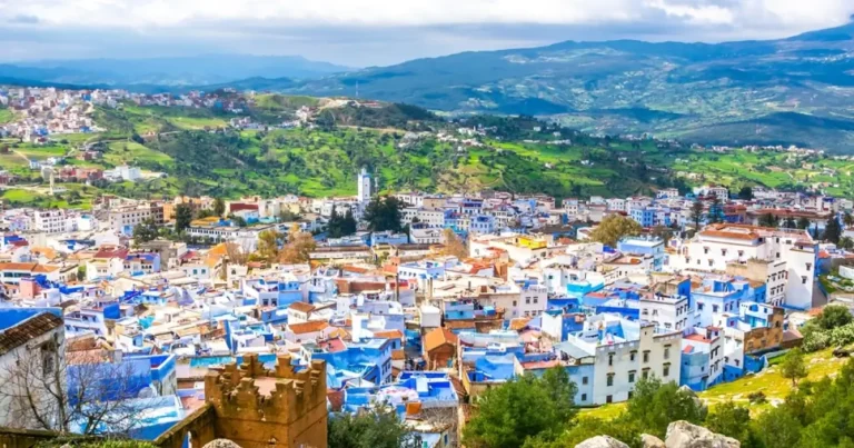 chefchaouen solo travel girl walking through blue alleyways and flower pots